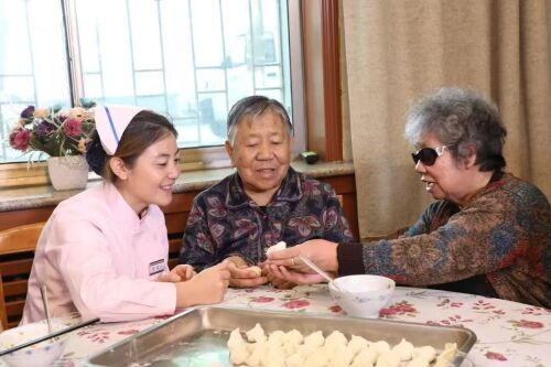 老人在康乐寿医护养老院一分院里包饺子